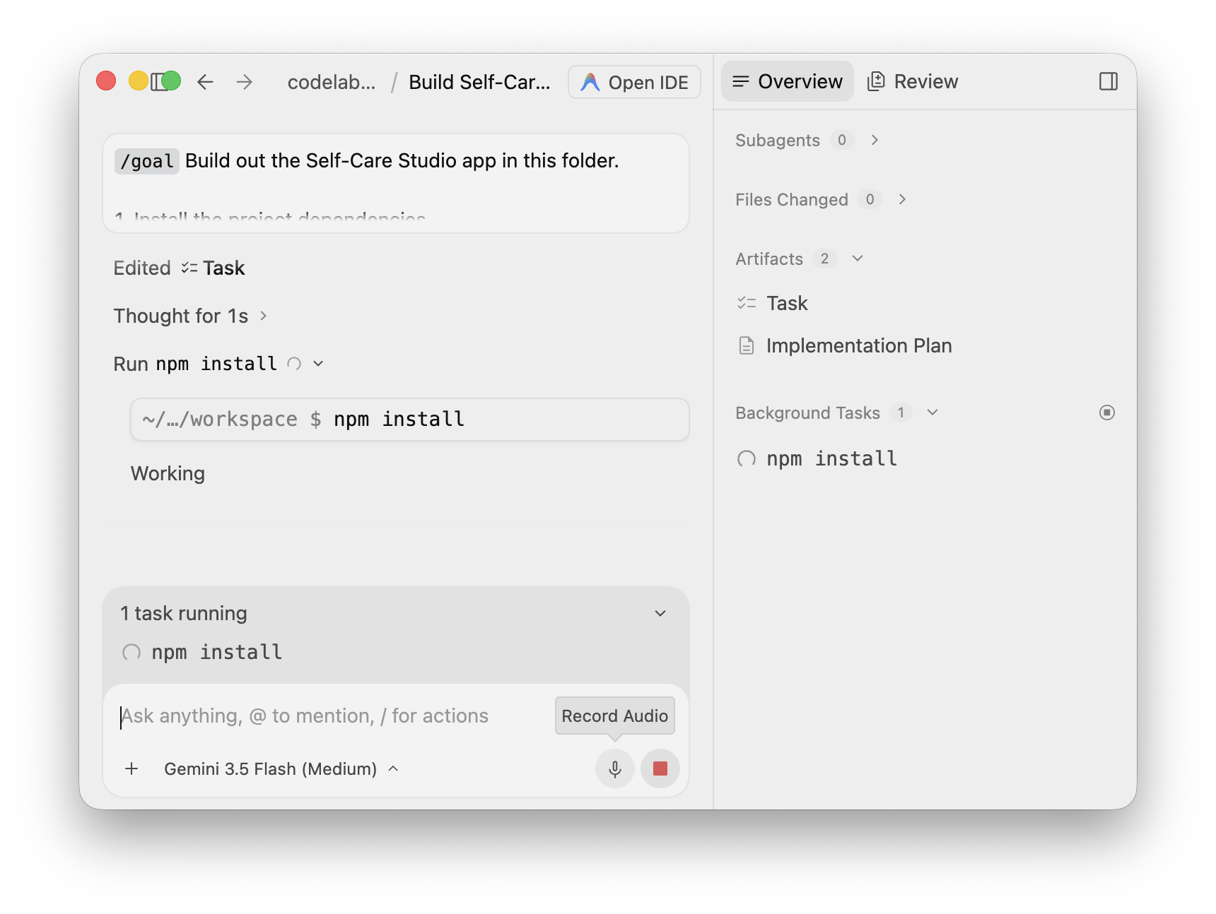 The agent has started npm install as a background task — the Overview panel shows it under Background Tasks and an inline &ldquo;1 task running&rdquo; indicator, while the agent keeps working